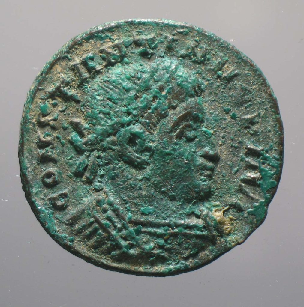 a photo of a roman coin with an Emperor's head on it.