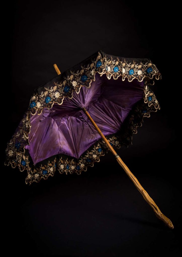 photo of a purple silk parasol with wooden handle 